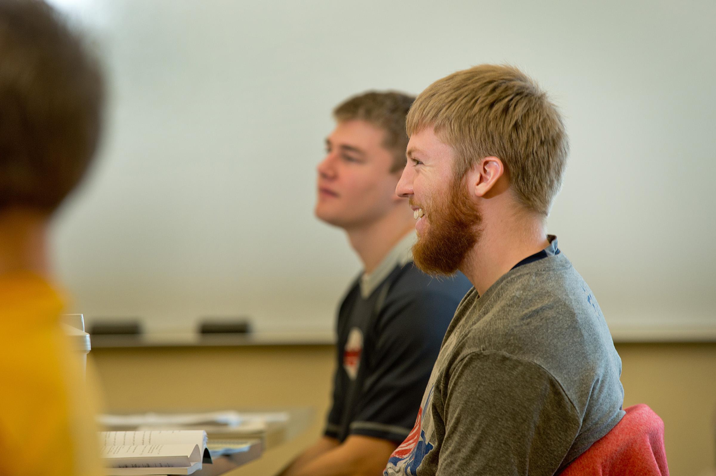 Students listening in class in front of a whiteboard